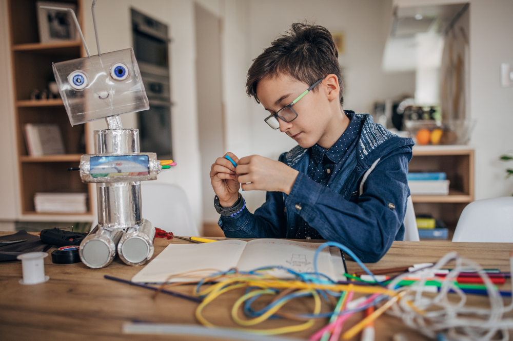 menino fazendo brinquedos de material reciclavél