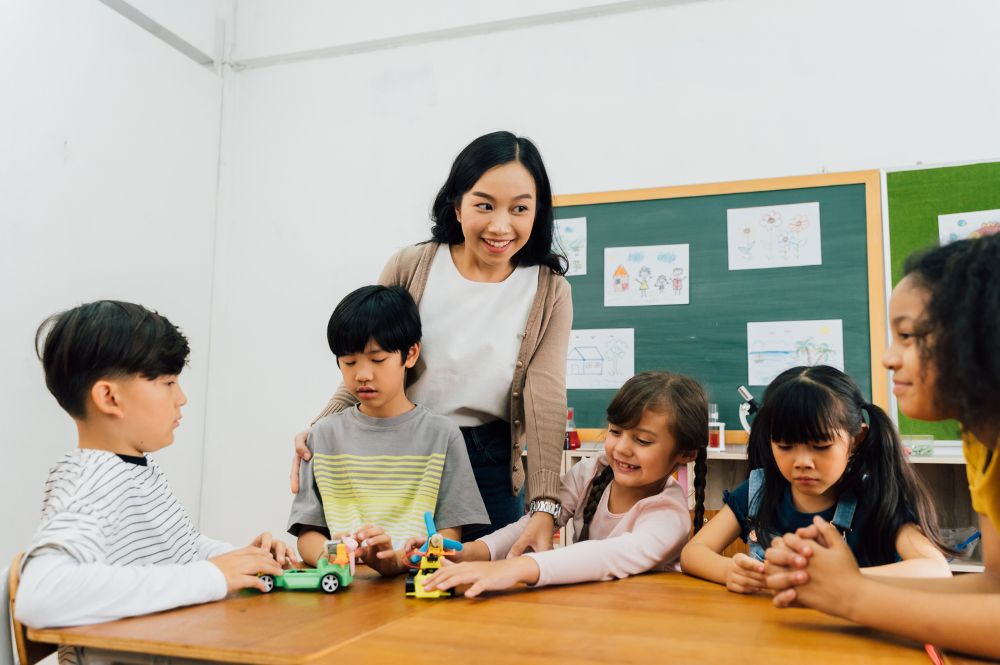 professora utilizando métodos de ensino e dando aula para crianças na escola com a utilização de brinquedos educativos